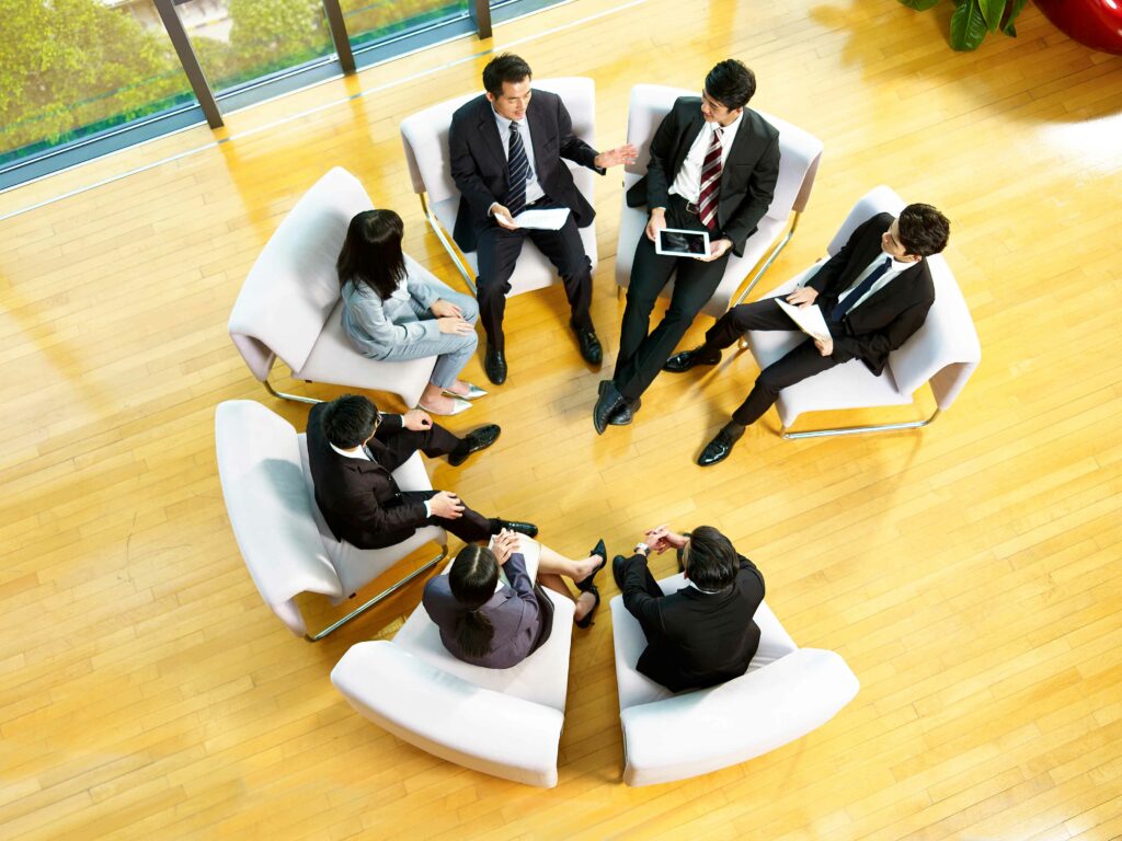 vue-en-grand-angle-d'une-équipe-d'hommes-d'affaires-asiatiques-assise-dans-un-cercle-de-réunion-au-pouvoir.