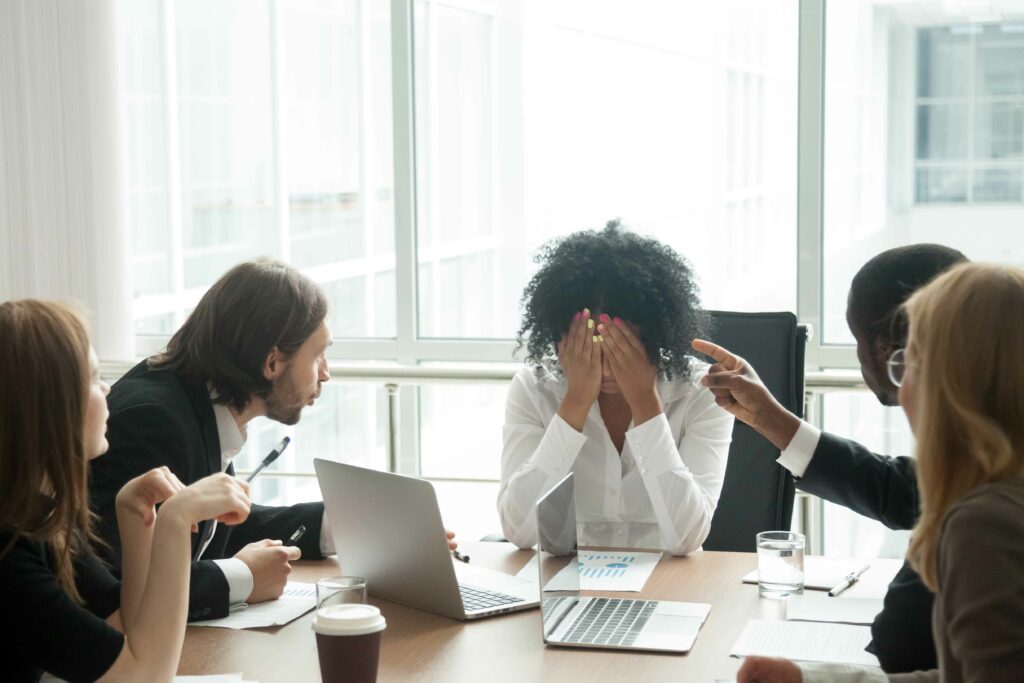Collégues de travail dans un bureau qui consolent une collègue qui pleure harcèlement