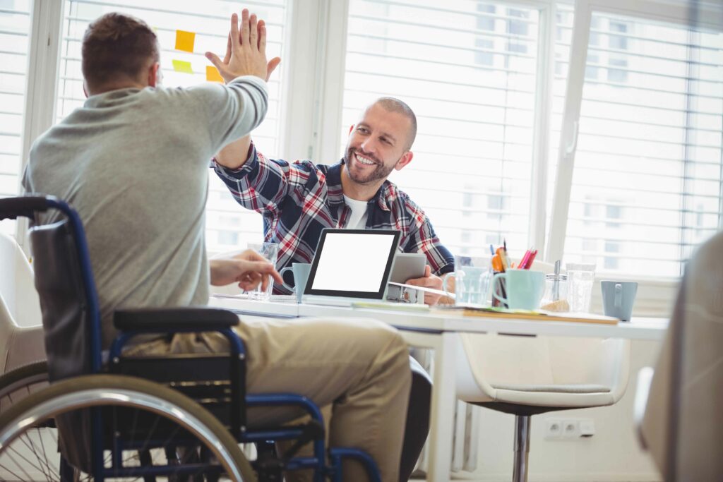 Homme d'affaires Handicap donnant cinq hauts en haut à un collègue de bureau créatif