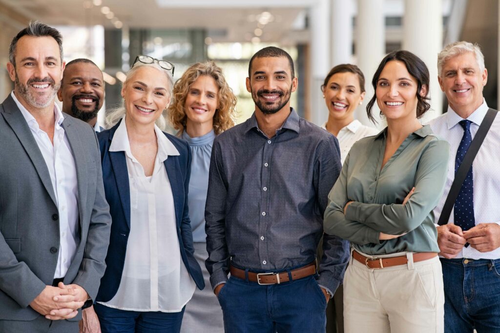 Portrait d'un groupe d'hommes d'affaires prospères au bureau moderne regardant la caméra. Portrait d'hommes d'affaires heureux et de femmes d'affaires satisfaites faisant partie d'une équipe. Groupe multiethnique de gens souriants.